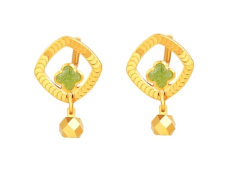 Puede incluir: Un par de pendientes dorados. Cada pendiente presenta un marco cuadrado con un centro verde en forma de trébol y un colgante dorado facetado. El marco está decorado con pequeños elementos curvos. Joyería.