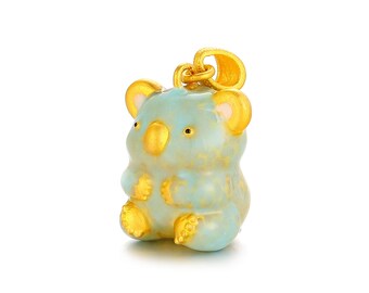 May include: A gold-colored koala bear pendant with a light blue body and gold accents. The pendant has a loop at the top for a chain. The koala has small black eyes and is in a sitting position.