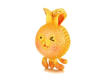 May include: A gold-colored bunny pendant with a winking eye and textured surface. The bunny has large ears and small feet. The pendant is likely made of gold and is designed to be worn as jewelry.