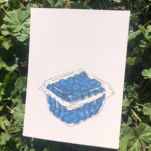 May include: A hand-drawn illustration of a container of blueberries. The container is made of clear plastic and has a blue lid. The blueberries are a dark blue color and are arranged in a neat pattern.