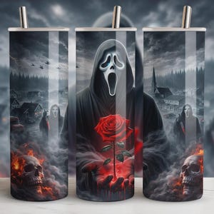 May include: A stainless steel tumbler featuring a spooky design. The artwork depicts a figure in a black robe and mask holding a red rose, with skulls and a town in the background. The design is set against a dark, cloudy sky.