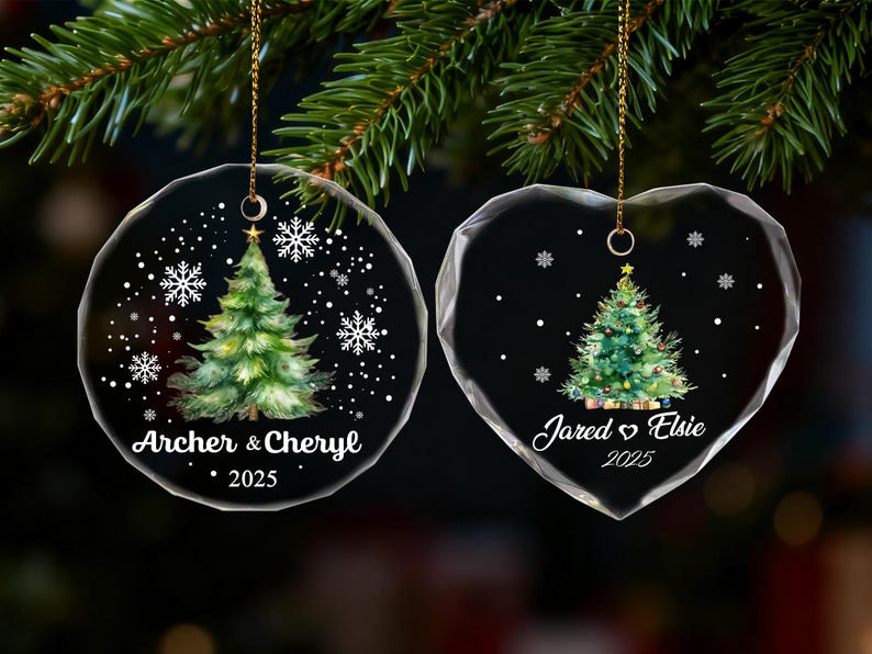 Pu&ograve; includere: Due decorazioni natalizie trasparenti, una rotonda e una a forma di cuore, ciascuna con un disegno ad acquerello di un albero di Natale. L'ornamento rotondo recita "Archer & Cheryl 2025". L'ornamento a cuore recita "Jared & Elsie 2025".
