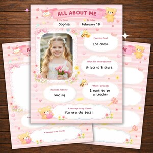 以下が含まれることがあります： 花を持つ子供の写真が載ったピンク色のAll About Meプリントシート。テディベア、カップケーキ、ハチのイラストで装飾されています。テキストには、My Name Sophia、Birthday February 19、Favorite Food Ice cream、Unicorns & stars、Dancing、I want to be a teacher、You are the best!と書かれています。