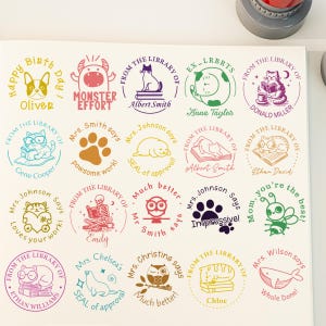 May include: A collection of custom stamps with various designs and text. The stamps feature illustrations of animals, objects, and phrases like "Happy Birthday," "Monster Effort," and "Impressive!" The stamps are in various colors and sizes.