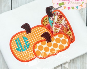 May include: White fabric with three appliqued pumpkins in orange, polka dot, and patterned fabrics. The largest pumpkin has a teal monogram. The design includes the text "Trendy Stitch Designs".