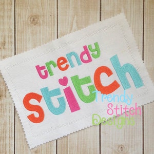 May include: A white fabric with the words "trendy stitch" embroidered in colorful letters. The letters are in different colors, including pink, orange, green, and blue. A small pink heart is between the words "trendy" and "stitch". The words "trendy stitch designs" are written in smaller letters below the main text.