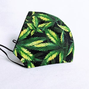 May include: Black face mask with a green and yellow marijuana leaf pattern.