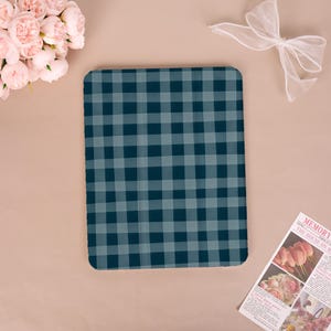 May include: A rectangular tablet case featuring a dark blue and light blue buffalo plaid pattern. The case has rounded corners and a smooth, flat surface. The design consists of a repeating grid of intersecting horizontal and vertical stripes.