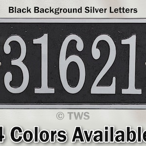May include: Black house number plaque with silver lettering. The number 31621 is displayed on the plaque.  The plaque has a black background and silver lettering.  The plaque is made of metal and has a slightly textured surface.  The plaque is rectangular in shape and has a beveled edge.  The plaque is approximately 10 inches wide and 6 inches tall.  The plaque is mounted on a white wall.  The text "TWS" is visible in the lower right corner of the plaque.  The text "4 Colors Available" is visible below the plaque.