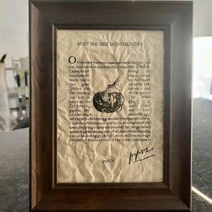 Puede incluir: Una impresión enmarcada con una estética vintage, que presenta un texto sobre el Basilisco, una criatura mítica. El texto describe al Basilisco como una serpiente mortal que puede matar con una sola mirada. La impresión está firmada "pipos" y fechada "página 724".