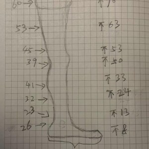 Puede incluir: Un boceto a l&aacute;piz de una pierna con medidas en cent&iacute;metros. El dibujo muestra una vista lateral de una pierna, con flechas y n&uacute;meros que indican diferentes longitudes. Las medidas var&iacute;an de 8 cm a 70 cm.