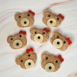May include: Seven brown felt bear appliques with red bows. Each bear has black eyes and a black nose.