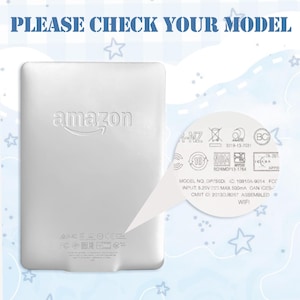 Puede incluir: Un dispositivo Kindle Amazon blanco con el logotipo de Amazon en relieve en la parte posterior. El texto "PLEASE CHECK YOUR MODEL" est&aacute; en la parte superior. El dispositivo tiene varios s&iacute;mbolos regulatorios e informaci&oacute;n del modelo.