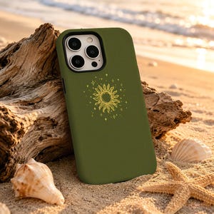 May include: An olive green smartphone case featuring a centered yellow line-art illustration of a sun surrounded by small stars. The case has a rectangular camera cutout with three circular lenses and a flash, positioned at the top left corner.