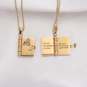 May include: Two gold-colored locket necklaces. One is closed, showing a butterfly design and a heart. The other is open, revealing the engraved text: "for you are always in mine" and "My love for you will never fade."