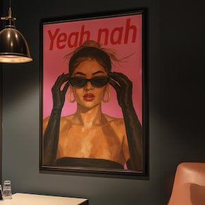 May include: Framed art print featuring a woman wearing sunglasses and black gloves, with the text "Yeah nah" in red. The woman has gold hoop earrings and red lipstick. The background is pink.