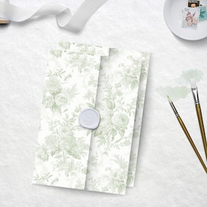 May include: Three white envelopes with a green floral pattern. The envelopes are stacked on top of each other. A white wax seal is on the top envelope.