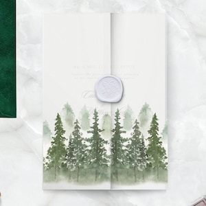Puede incluir: Invitación de boda con un diseño de bosque en acuarela en tonos verdes. La invitación está sellada con un sello de cera blanco. Un sobre verde esmeralda es visible en el fondo. La invitación incluye los nombres de la pareja y la palabra "Celebrar".