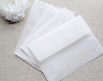May include: A stack of white envelopes with a smooth, matte finish. The envelopes are folded and ready to be used for sending letters or invitations.