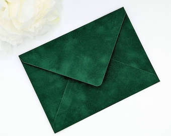 May include: A deep forest green envelope with a textured, matte finish. The envelope is rectangular in shape with a classic pointed flap design, featuring a consistent, rich emerald hue across its entire surface, presented in a clean, flat orientation.