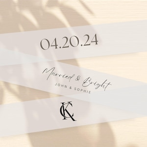 May include: White ribbon with the text "04.20.24" and "Married & Bright John & Sophie" and the monogram "K" in black.