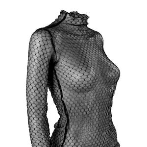 May include: A black, long-sleeved top with a high, ruffled neckline. The top is made of a fishnet-like material, creating a see-through effect. The garment is designed to be form-fitting.