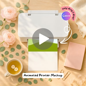 May include: A white printer with a printed landscape design is the focal point of this image. The printer is surrounded by pink flowers, green leaves, a cup of tea, a pink notebook, and gold paper clips. The text "Animated Printer Mockup" is at the bottom.