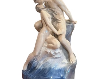 Una gran escultura de porcelana de una pareja besándose junto al mar de Royal Copenhagen
