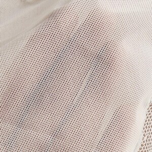 May include: A sheer white mesh fabric with a fine grid pattern. The material is translucent, revealing a subtle texture throughout the surface. Along the top and bottom edges, there is a decorative white lace trim with a scalloped floral design.