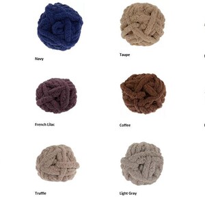 Pode incluir: Variedade de novelos de l&atilde; grossa em v&aacute;rias cores, incluindo Spa Blue, Navy, Taupe e Medium Grey. Cada novelo &eacute; rotulado com o nome da cor. Ideal para projetos de artesanato.