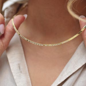 May include: A gold necklace with the words "Mom Forever & I Love You" engraved on it.