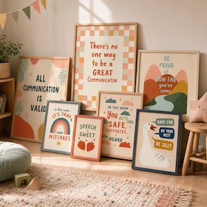 Op de afbeelding: Een collectie van zeven ingelijste wandposters met motiverende teksten en illustraties, waaronder een regenboog, aardbeien, bergen en een gans. De prints zijn ingelijst in licht houten lijsten met diverse kleurrijke ontwerpen.