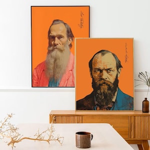 May include: Two framed portrait prints with orange backgrounds. One features a man with a long white beard and a pink jacket. The other shows a man with a dark beard and a blue jacket. Both have signatures.