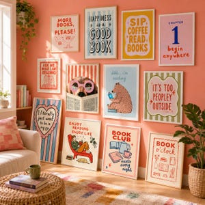 Puede incluir: Una pared de galería con doce láminas enmarcadas con diversas ilustraciones y tipografías sobre libros, incluyendo frases como More Books Please, Happiness is a Good Book, Sip Coffee Read Books y Book o'clock, expuestas sobre una pared color coral.