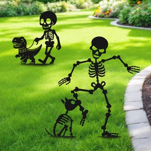 May include: Black metal lawn decorations featuring skeleton figures. One skeleton walks a dinosaur on a leash, while another interacts with a skeleton dog. The figures are set on a green lawn, perfect for Halloween.