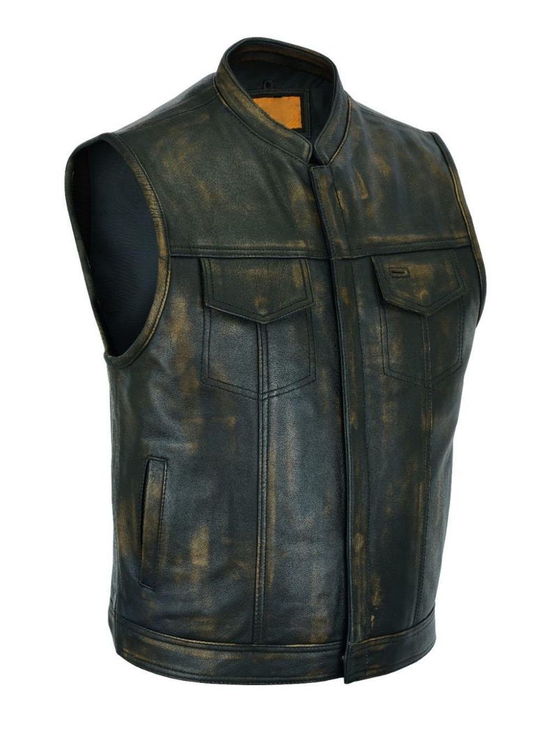 K&ouml;nnte beinhalten: Eine schwarze Lederweste mit Stehkragen und zwei Brusttaschen. Die Weste hat ein verwittertes, Vintage-Aussehen mit braunen Akzenten. Ein kleines Etikett ist am Kragen sichtbar.