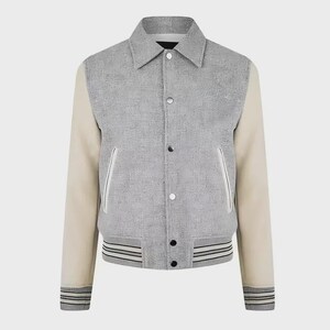 May include: A gray and cream-colored varsity jacket. The jacket features a gray body with cream-colored sleeves. It has a button-up front, two front pockets, and striped detailing on the cuffs and hem. The collar is a classic, pointed style.