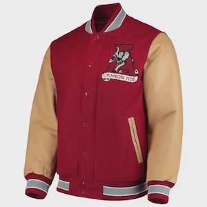 May include: A red and tan varsity jacket with a button-up front. The jacket features tan sleeves, a red body, and a white, gray, and red striped trim on the cuffs and hem. A patch on the chest reads "CRIMSON TIDE" with a stylized elephant.