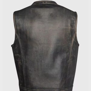 May include: A distressed black leather vest with a stand-up collar. The vest has a worn, vintage appearance with visible texture and subtle color variations. The back view showcases the vest's tailored design and stitching details. A classic piece of outerwear.