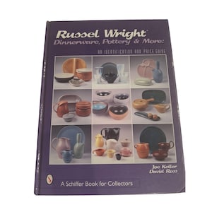 May include: A hardcover book titled Russel Wright Dinnerware, Pottery & More: An Identification and Price Guide by Joe Keller and David Ross. The purple cover features a grid of nine photographs displaying various colorful ceramic pottery pieces.