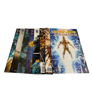 May include: A collection of comic books featuring various characters and titles. The covers display vibrant illustrations and text, including the title "Captain Atom Armageddon." The comics are stacked together, showcasing a variety of colors and designs.