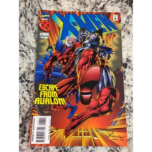 May include: A white ceramic mug with a black handle and the text "But First, Coffee" in a bold, black font. The mug is sitting on a wooden surface. The mug is 4 inches tall.