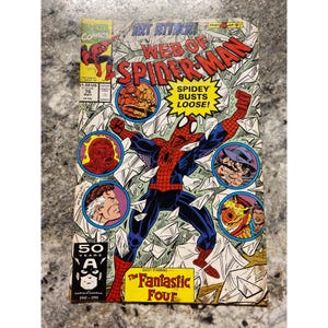 May include: A vintage comic book titled "Web of Spider-Man" featuring Spider-Man in a dynamic pose. The cover includes the text "Spidey Busts Loose!" and "The Fantastic Four." The comic is from Marvel Comics, issue #76.