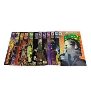 May include: A collection of comic books, featuring various covers with vibrant illustrations and text. The comic books are stacked together, showcasing a range of colors and artistic styles. The cover art includes characters and titles.