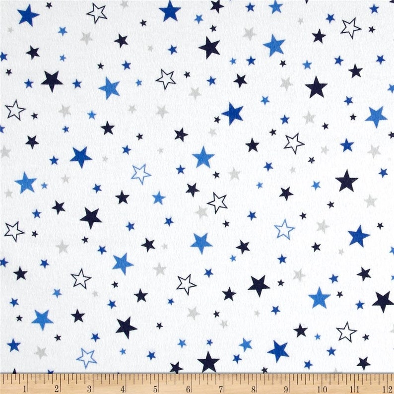 K&ouml;nnte beinhalten: Wei&szlig;er Stoff mit einem sich wiederholenden Muster aus blauen, grauen und schwarzen Sternen. Die Sterne sind in verschiedenen Gr&ouml;&szlig;en und zuf&auml;llig &uuml;ber den Stoff verteilt.
