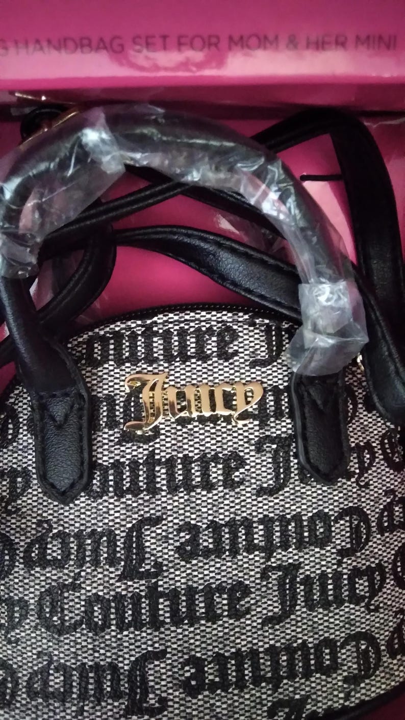 May include: A black and white handbag set with the text "Couture Juicy" in gold lettering. The bag has a black handle and the words "HANDBAG SET FOR MOM & HER MINI" are visible.