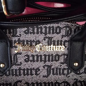 May include: Black and white patterned handbag with black handles and gold hardware. The bag features the text "Juicy Couture" in gold lettering. The bag has a black strap and a gold buckle.