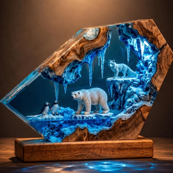 A hand-poured epoxy resin diorama that encases a polar bear and penguin in a glowing arctic iceberg scene — tiny sculptural world you can light up on your desk.