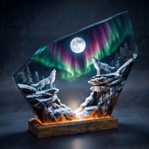 A hand-cast resin lamp trapping a howling wolf scene under aurora borealis skies — the kind of moody, sculptural night light you genuinely can't find at Target.