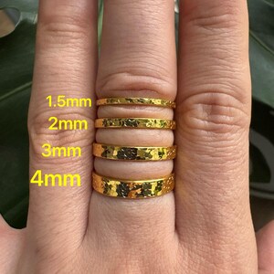 Puede incluir: Primer plano de una mano con cuatro anillos dorados martillados. Los anillos miden 1,5 mm, 2 mm, 3 mm y 4 mm de ancho. Los anillos tienen una superficie texturizada y un acabado brillante. El texto "1,5 mm", "2 mm", "3 mm" y "4 mm" es visible.
